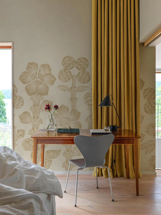 Storflax is a bright, playful mural wallpaper featuring a graphic pattern of pale yellow fantasy flowers stretching from the floor to the ceiling over a lightly textured, warm beige base.