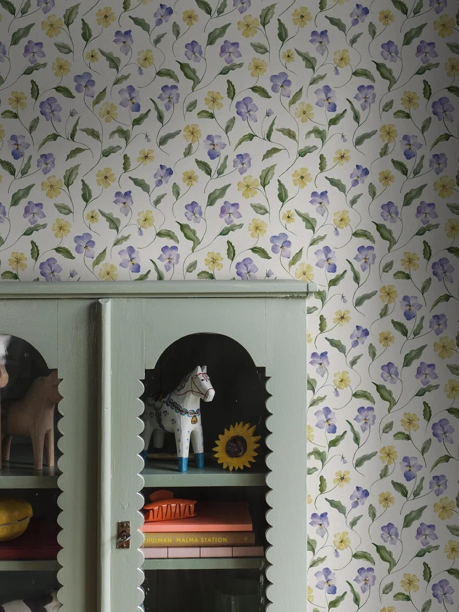  The wallpaper is hand-painted in purple, blue and pale yellow on a light beige background with a paper-like texture, reminiscent of unbleached pressed paper. 