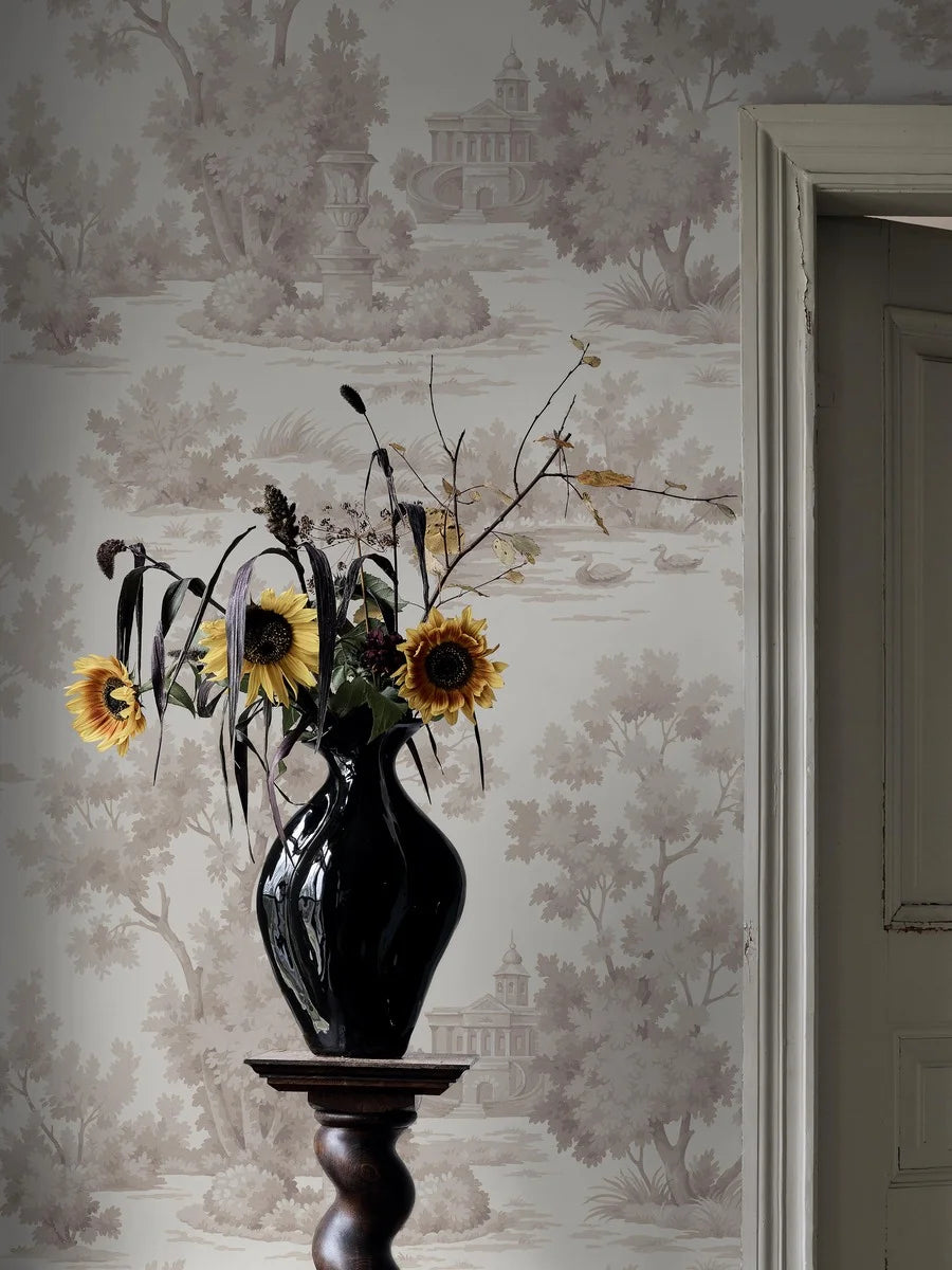 Grisaille is a light, decorative wallpaper with a stylized landscape motif in grey-beige tones on a white background.