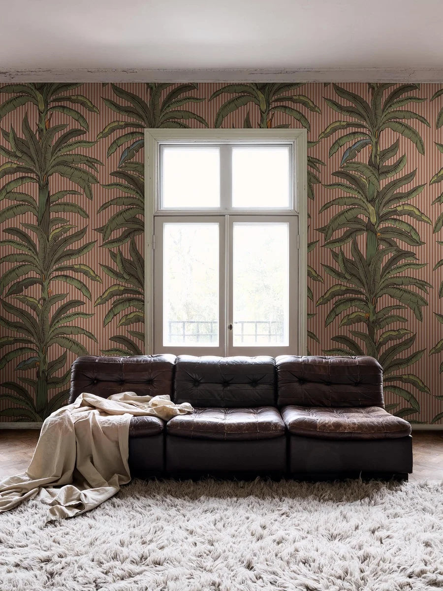 Wallpaper printed custom fit on demand in multiple colorways. Here, green palms stand out against a warm apricot-pink background.