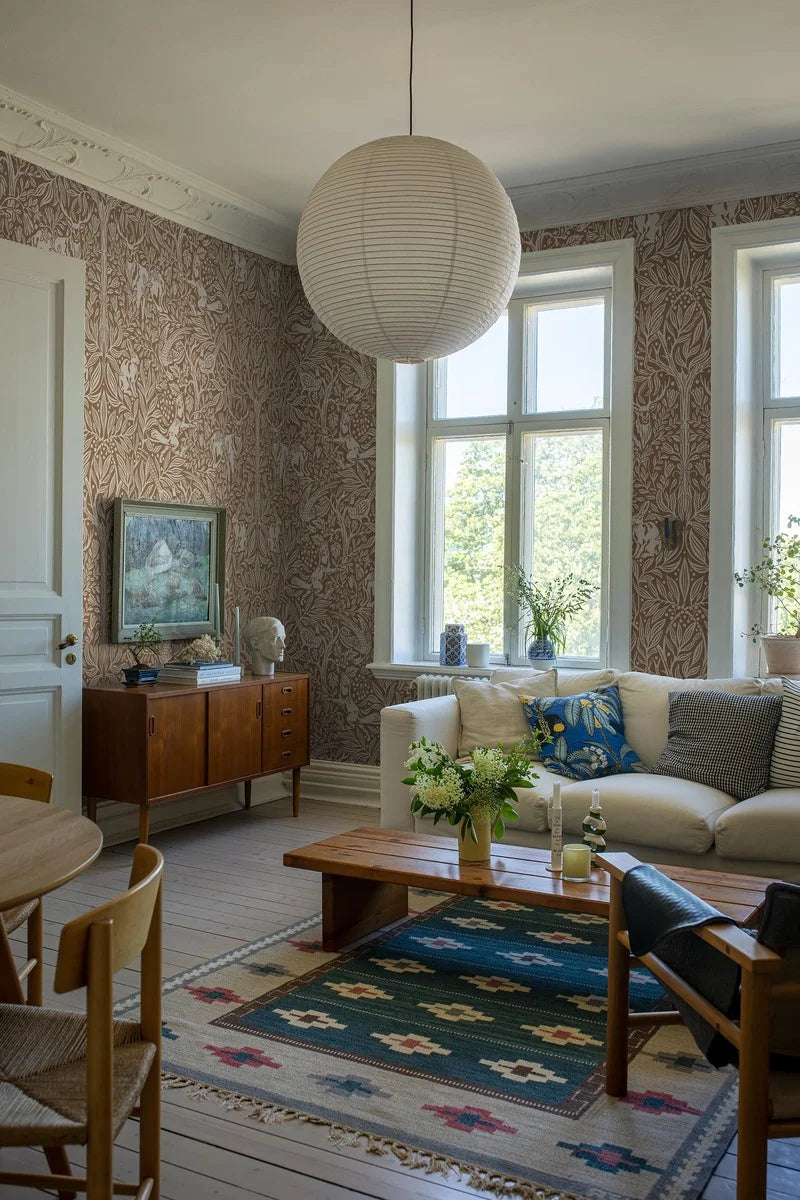 This is an enlarged digital reprint of the Under the Elder Tree wallpaper. Here, the wallpaper has a warm reddish-brown background with light gray-beige details.