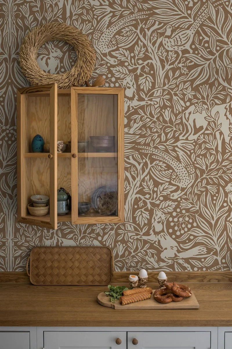 This is an enlarged digital reprint of the Under the Elder Tree wallpaper. Here, the wallpaper has a warm reddish-brown background with light gray-beige details.