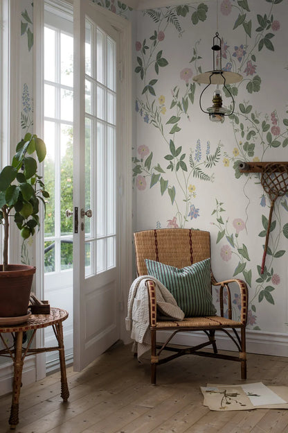 Floral Midsummer Eve Grand climbs toward the ceiling like a summery, delicate wall painting with buttercups, columbines, bellflowers, clover, and other blossoms in a light pastel palette on a cream-white background.