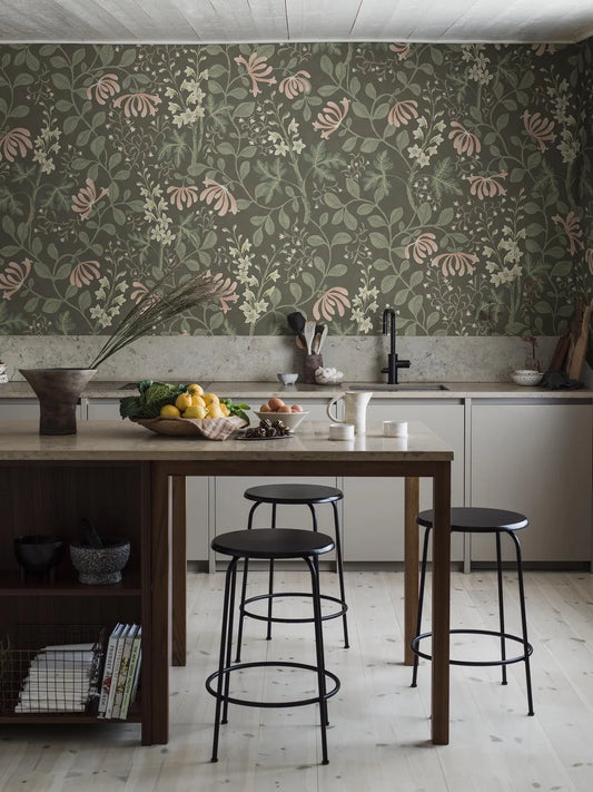 The Trädgårdsfröjd Grand mural wallpaper is covered in cream-coloured delphiniums and pale apricot-pink honeysuckle set within green, winding foliage on a dark green background