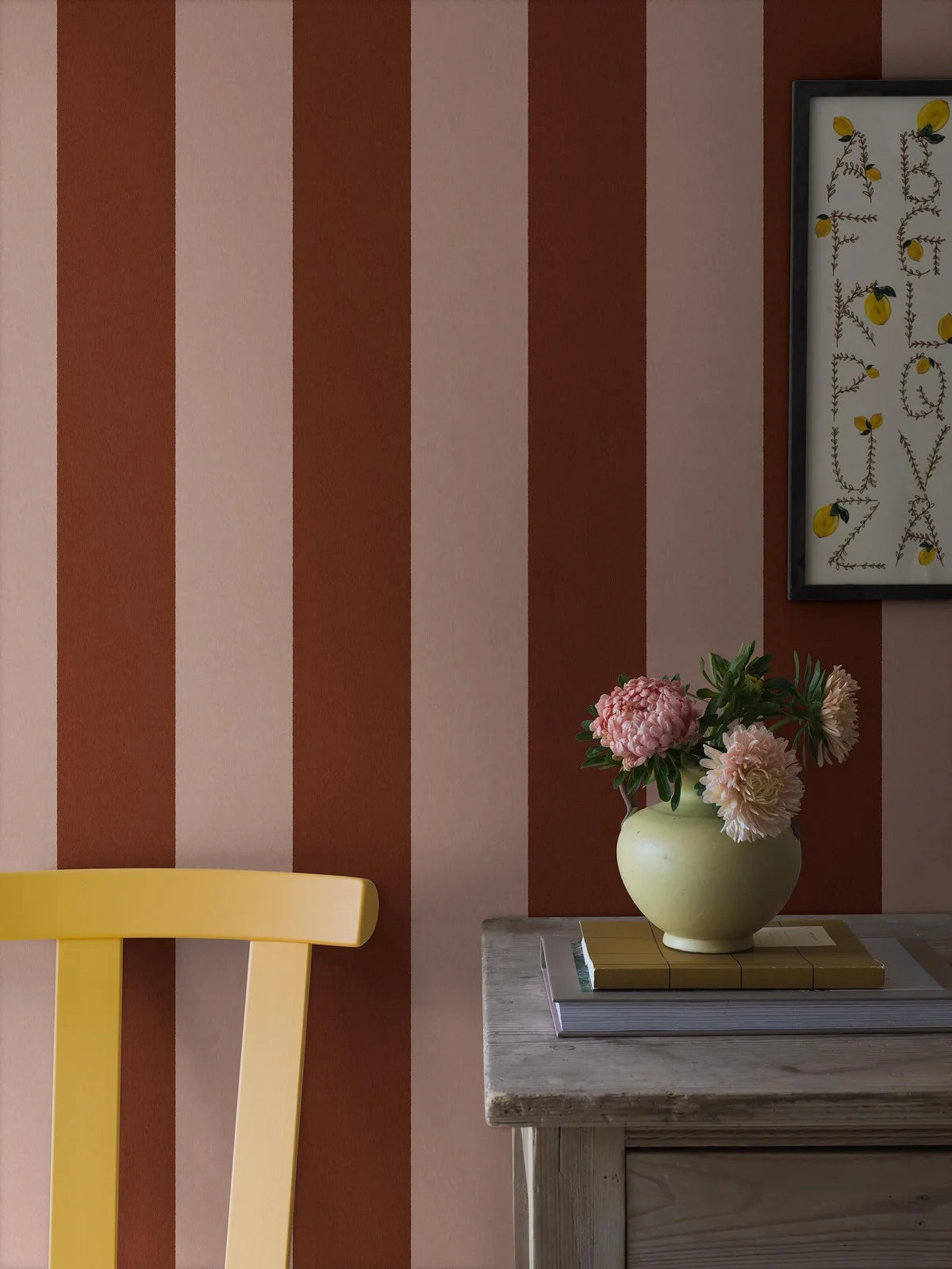 The wide-striped Båstad Stripe wallpaper feels warm and vibrant, with block stripes in raspberry red and warm light pink.