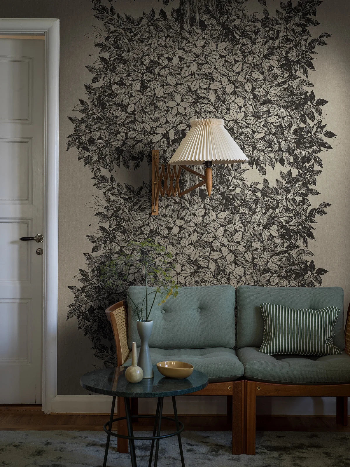 Here, the Hassel mural wallpaper features black details on a grey-brown ground reminiscent of undyed linen. The wallpaper is printed to order, made to measure for your wall.
