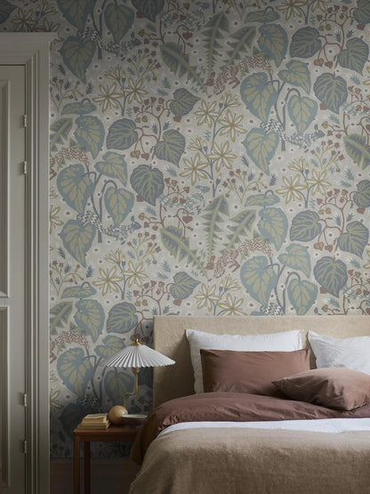In the large-scale botanical pattern of the mural wallpaper Zingkorre, squirrels dart back and forth among flowers and leaves.