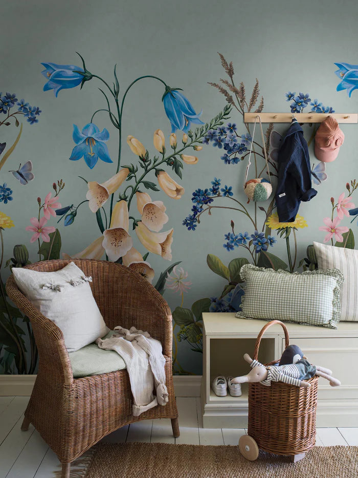 On the Bluebell Magic mural wallpaper, meadow flowers — bluebells, clover, dandelions, and forget-me-nots — stretch gracefully toward the ceiling
