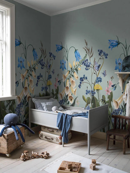 On the Bluebell Magic mural wallpaper, meadow flowers — bluebells, clover, dandelions, and forget-me-nots — stretch gracefully toward the ceiling