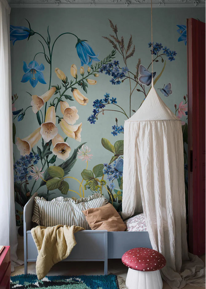 On the Bluebell Magic mural wallpaper, meadow flowers — bluebells, clover, dandelions, and forget-me-nots — stretch gracefully toward the ceiling