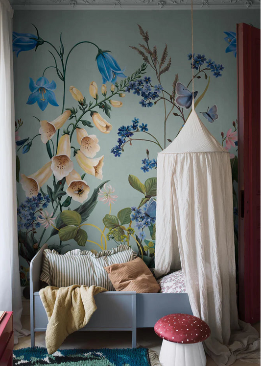 On the Bluebell Magic mural wallpaper, meadow flowers — bluebells, clover, dandelions, and forget-me-nots — stretch gracefully toward the ceiling