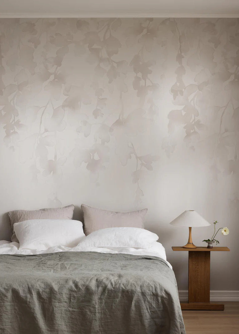 The light wallpaper mural Dawn Forest features hand-painted watercolor foliage that drapes softly down the wall. 