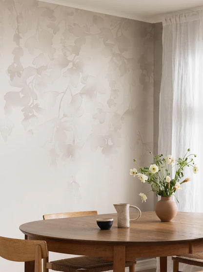 The light wallpaper mural Dawn Forest features hand-painted watercolor foliage that drapes softly down the wall.