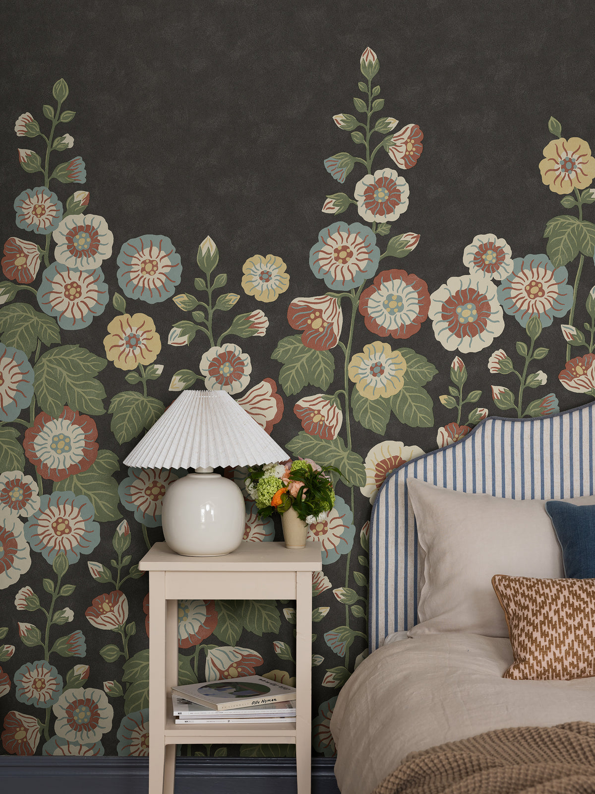Happy Hollyhocks Grand is a magnificent floral wallpaper where lush hollyhocks climb across the wall. 