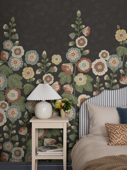 Happy Hollyhocks Grand is a magnificent floral wallpaper where lush hollyhocks climb across the wall. 