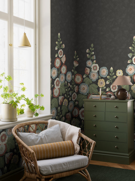 Happy Hollyhocks Grand is a magnificent floral wallpaper where lush hollyhocks climb across the wall. 