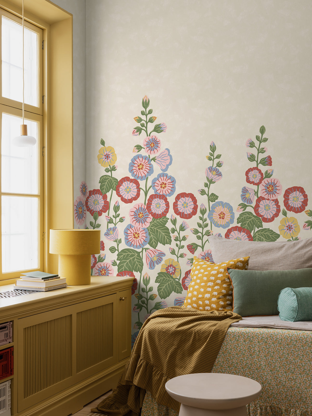 Happy Hollyhocks Grand is a vibrant floral wallpaper where stately hollyhocks adorn the wall with color, joy and character. 
