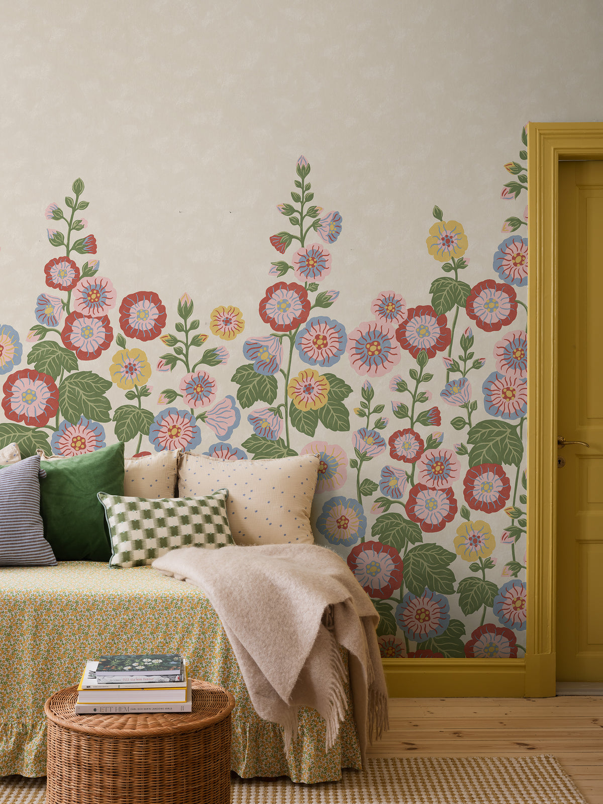 Happy Hollyhocks Grand is a vibrant floral wallpaper where stately hollyhocks adorn the wall with color, joy and character. 