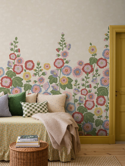 Happy Hollyhocks Grand is a vibrant floral wallpaper where stately hollyhocks adorn the wall with color, joy and character. 