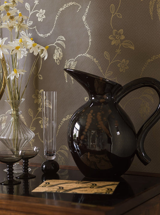 With its rich dark brown background offsetting a luxurious floral pattern in shimmering gold, our Elsie wallpaper has a cosy yet luxurious charm. 