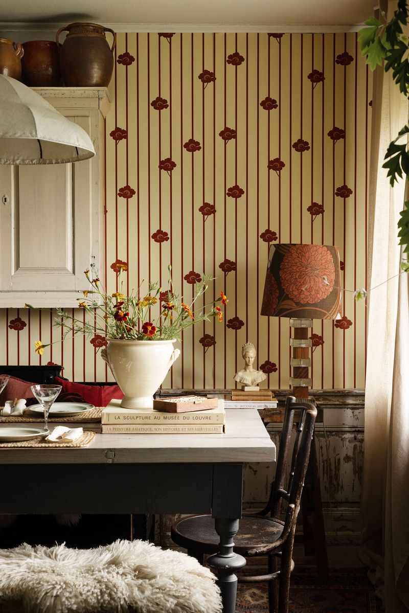This wallpaper features soft, muted stripes that bring structure and calm, while the flowers defy the order, claiming space and growing freely.