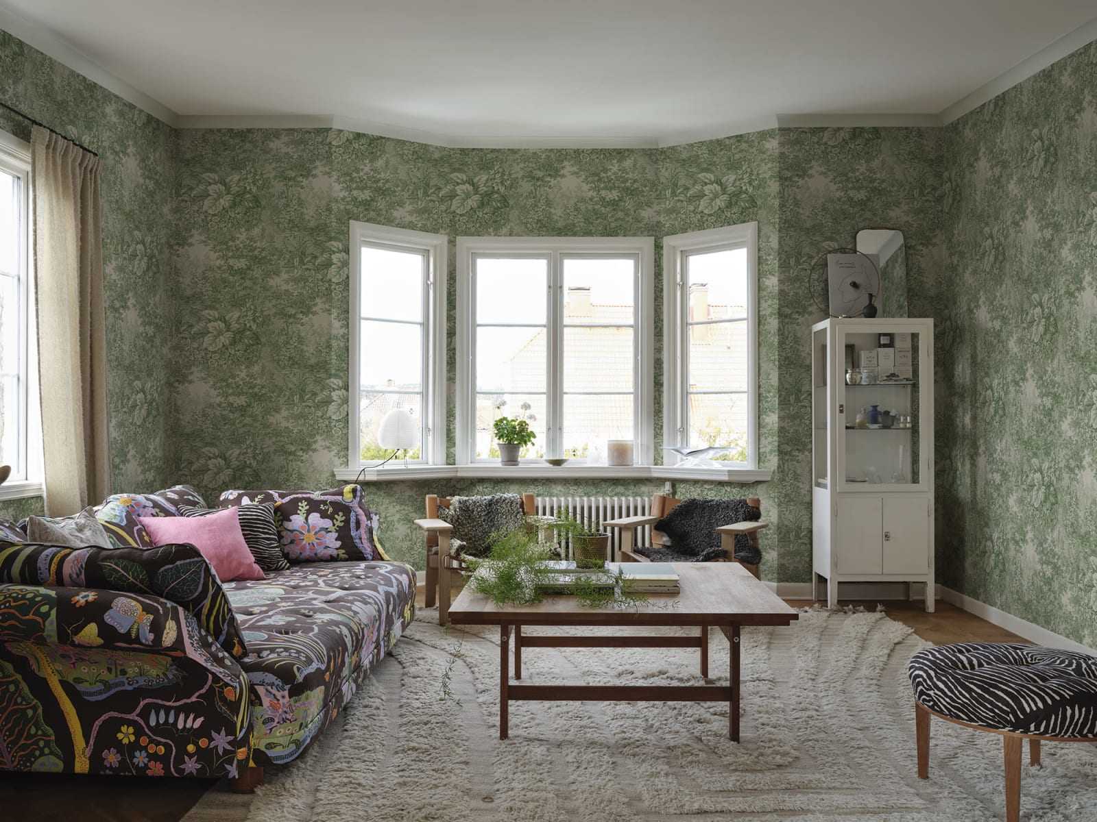 Based on a textile print from 19th century France featuring lush forest clearings that lay the wallpaper like an embracing blanket over the walls.