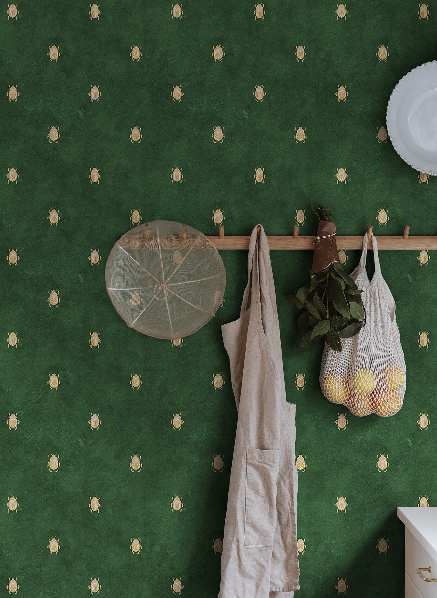 Wallpaper with stylized scarabs with decorative detailing in a row against a patinated background create a bold and chic atmosphere on the walls.