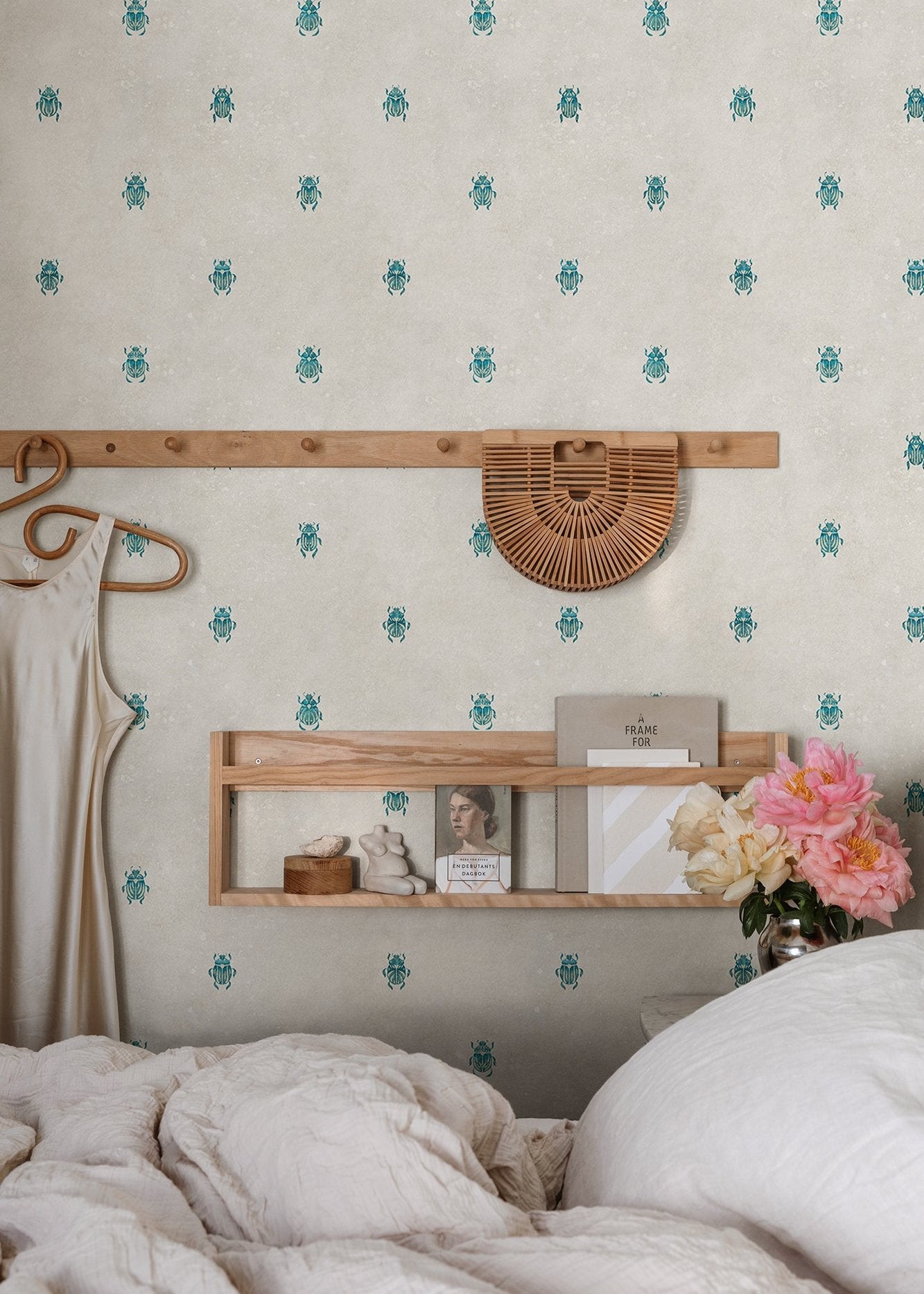 Wallpaper with stylized scarabs with decorative detailing in a row against a patinated background create a bold and chic atmosphere on the walls.
