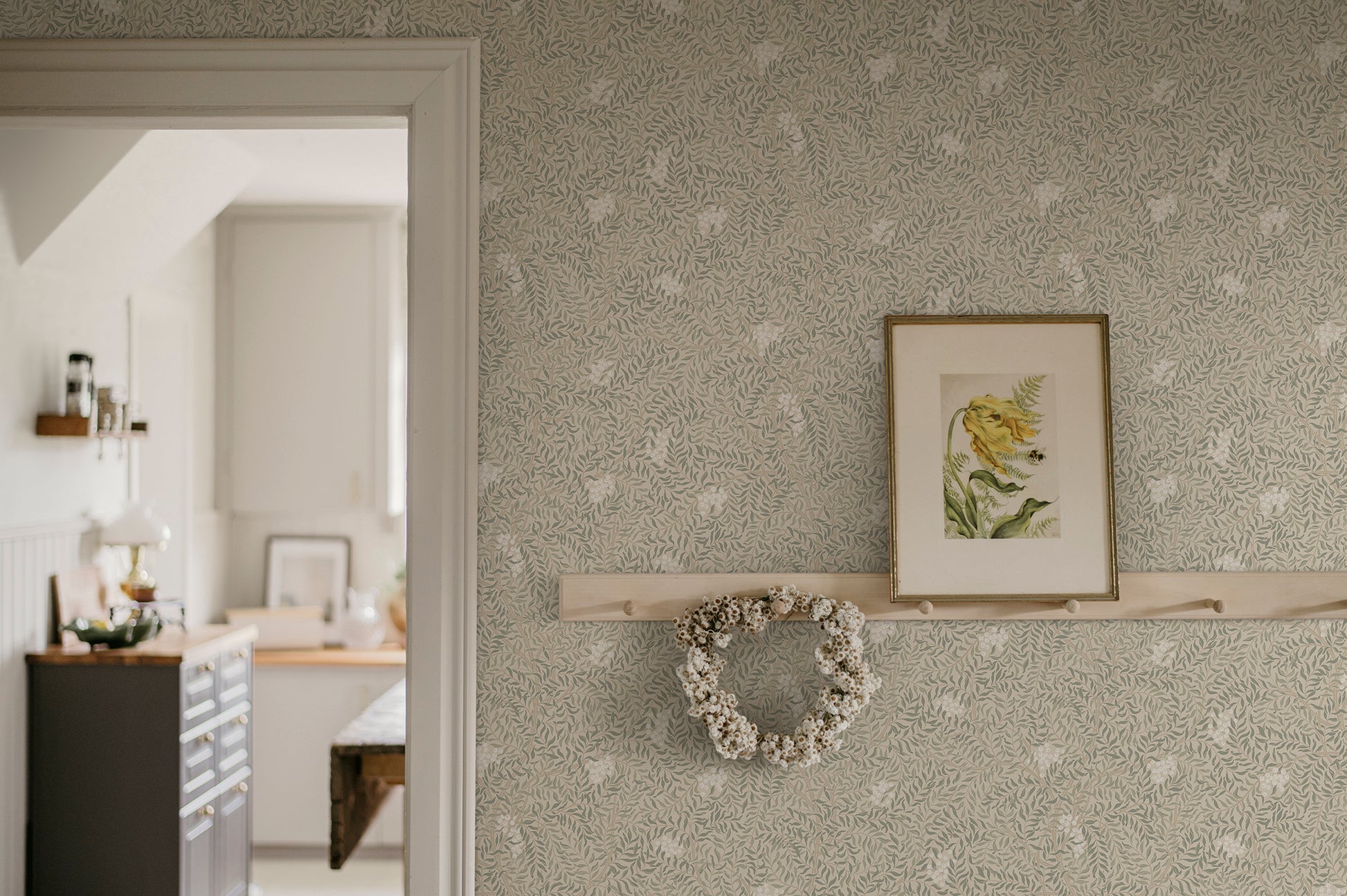 A harmonious surface-printed wallpaper pattern featuring intricate rowan berry branches creates a cozy and welcoming atmosphere with its stylized and enveloping design.