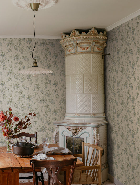 Wallpaper Lovisa with an airy watercolor featuring clusters of wisteria that exudes a romantic, rural charm with a contemporary touch. Lovisa, Blue, has a warm beige base with a delicate pattern in lovely soft blue and green hues.