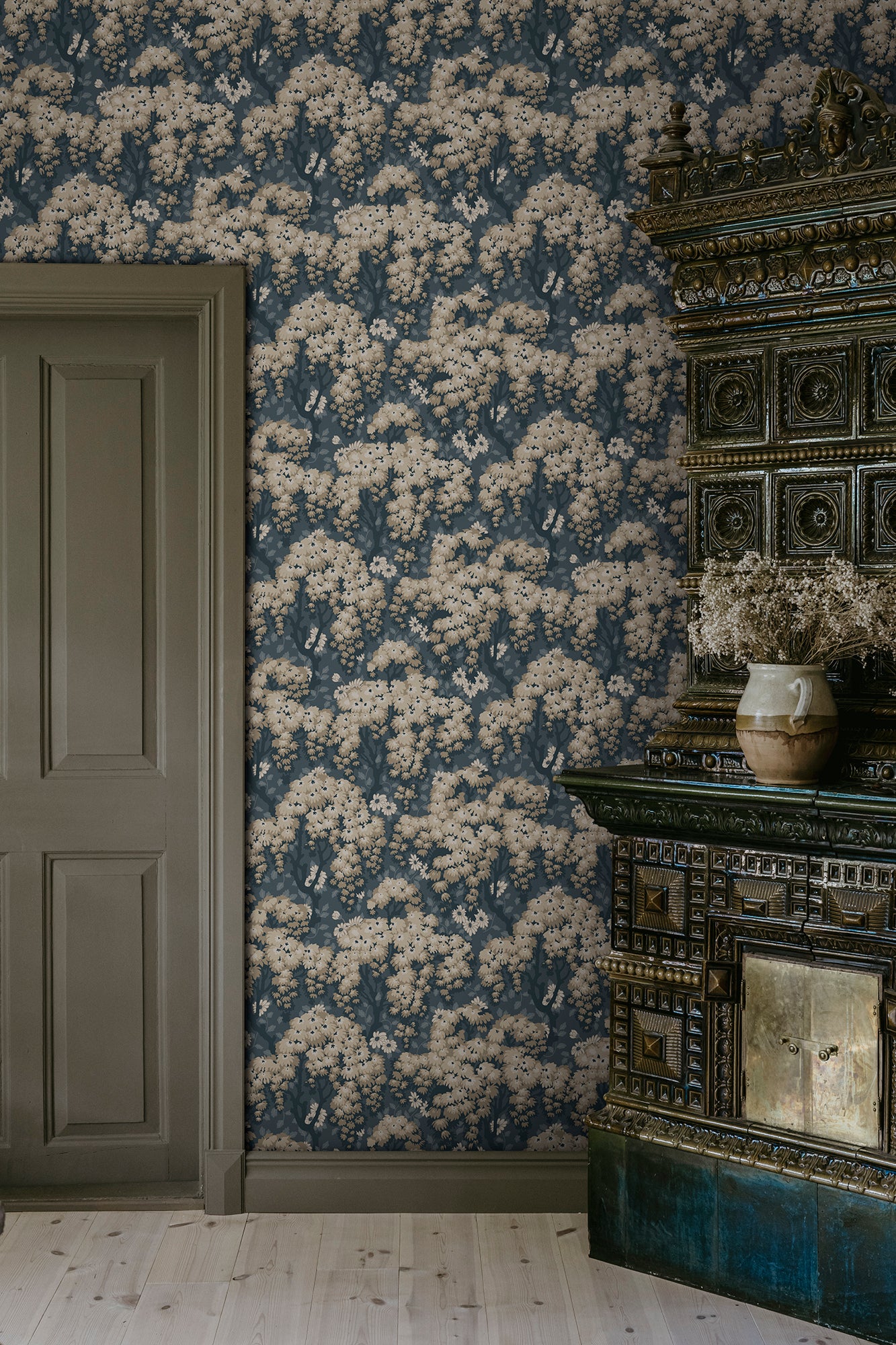 Lush tree canopies against a meadow of daisies create a harmonious, large-patterned wallpaper curtain on the wall.