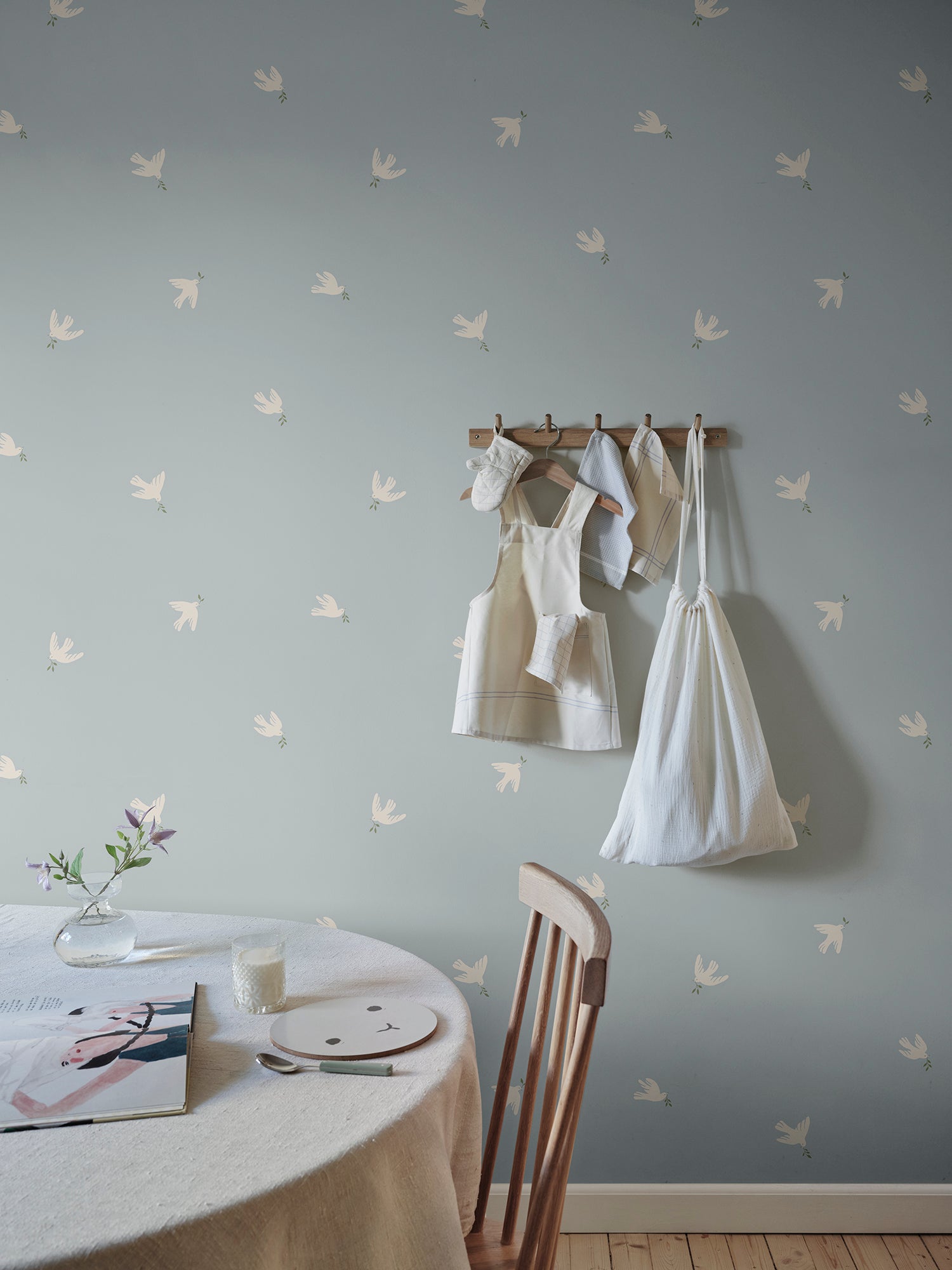 Let tranquility float into your space with the Frida light blue wallpaper, where graceful doves carry peaceful vibes across your walls.
