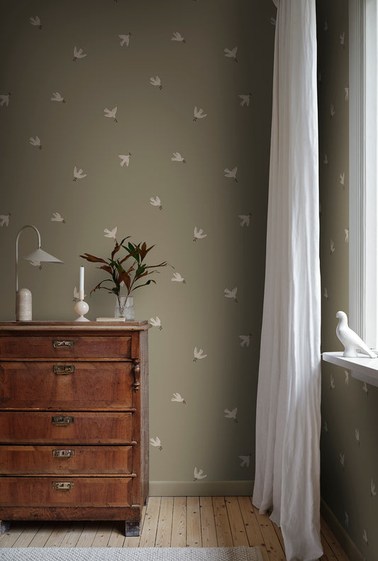The Frida wallpaper creates a sanctuary of peace with gentle doves of peace in an olive green canvas.