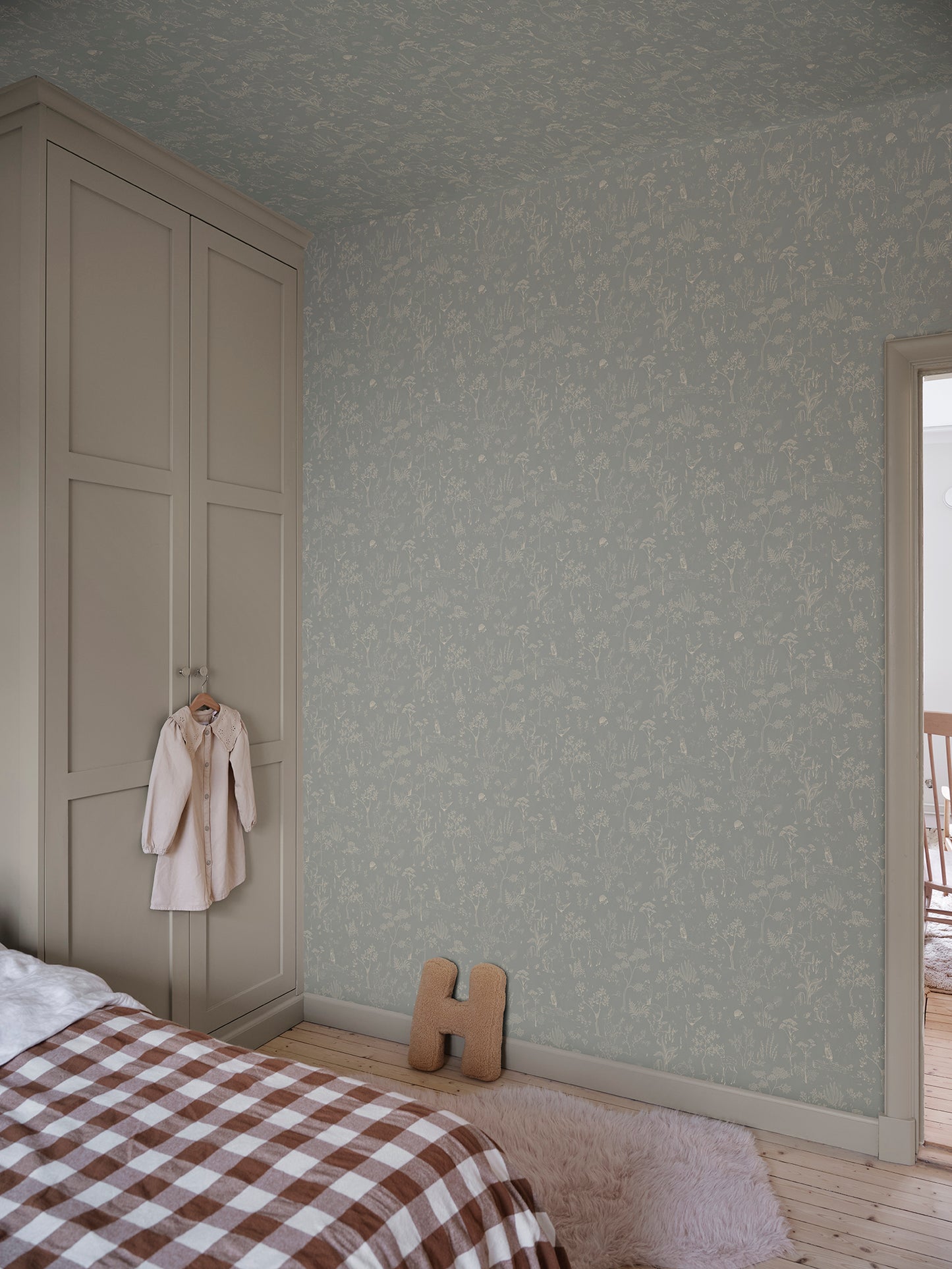 Discover the Hollie wallpaper, where a misty blue backdrop unfolds a fantasy forest teeming with whimsical animals and delicate botanical details.