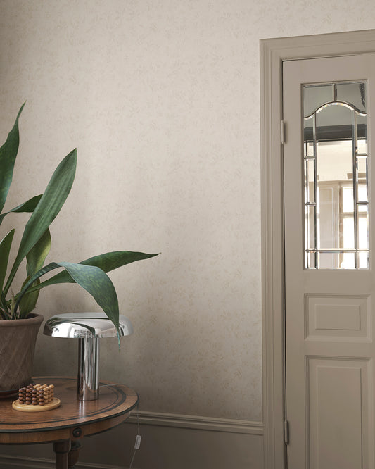 Infuse your space with the elegance of the Mila Beige wallpaper. This pattern, inspired by antique al fresco paintings, features romantic leafy vines with a warm patina. The subtle depth and aged aesthetic seamlessly blend into any room, bringing a touch of timeless sophistication.