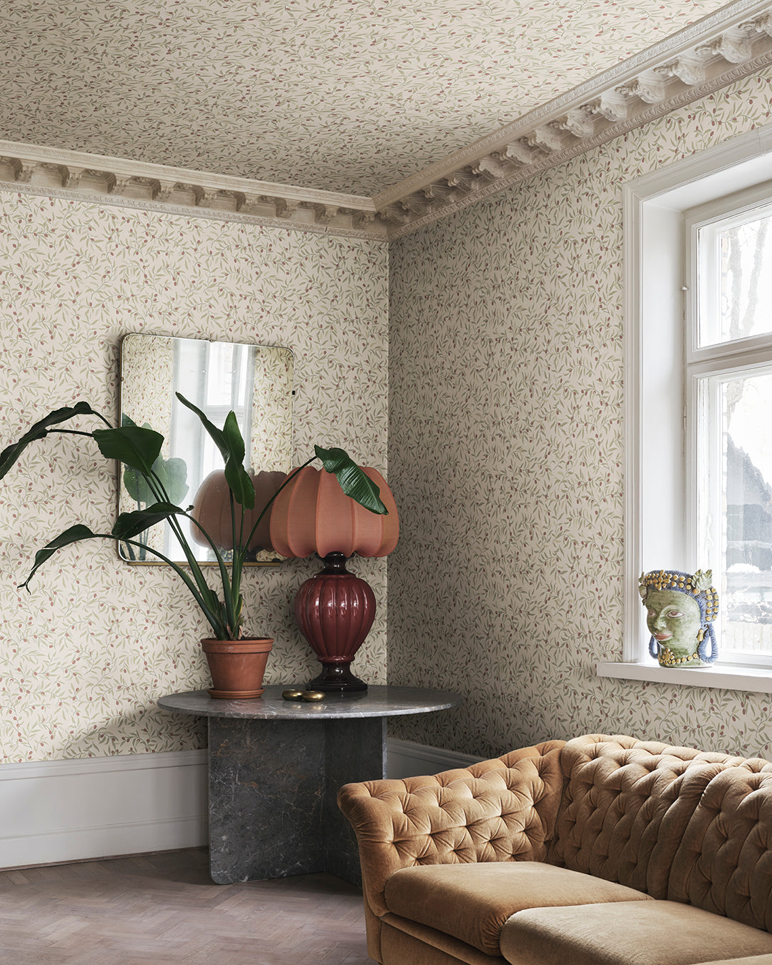 Winding olive branches with vibrant burgundy olives create an airy yet embracing character.