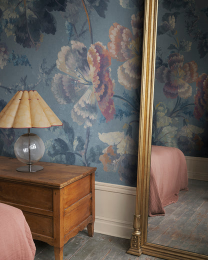 Immerse your space in a stunning floral cavalcade with Ines, where soft painterly blooms meander across a serene blue backdrop. This 19th-century inspired design creates a seamless blend of history and elegance, making every room a visual delight.