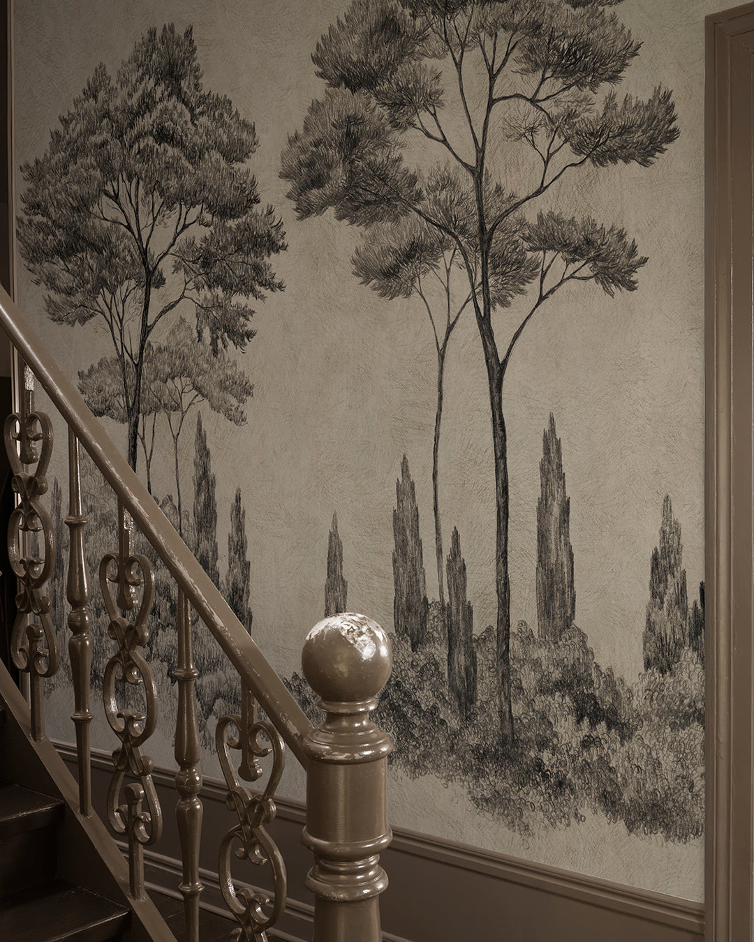 Discover the timeless charm of the Andrea mural in graphite. This hand-drawn mural transports you to Italian gardens with lush conifers and cypress trees. The historical style adds depth and sophistication, enriching your space with an elegant, etched look.