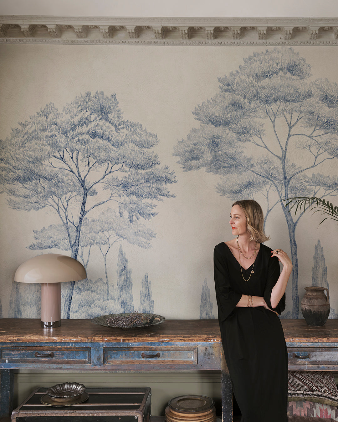 Enhance your space with the Andrea mural's classical charm. Featuring hand-drawn Italian gardens in serene blue, this piece infuses any room with historical and natural beauty. Tall conifers stand majestically, creating a sense of depth and timeless elegance that transforms your walls into a picturesque landscape.
Designed by Karolina Kroon
