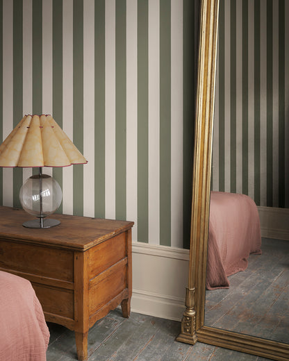 Elevate your space with the timeless elegance of the Sam wallpaper in forest green. Its rich, bold stripes bring a touch of Southern European charm and sophistication, effortlessly blending into any interior style with a striking yet harmonious design.
