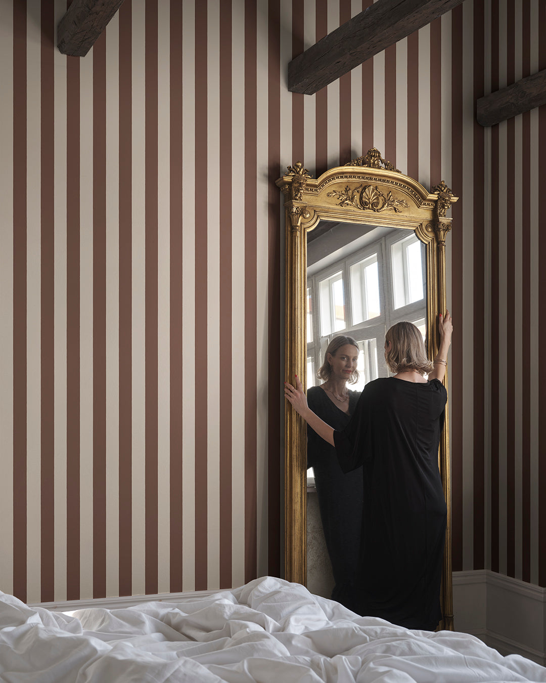 Sam in Burgundy is a sophisticated stripe pattern, blending Southern European elegance with rich, warm colors. Ideal for creating visual height and adding a touch of timeless charm to any space. This wallpaper can be used alone or paired with other designs for a coordinated look.
