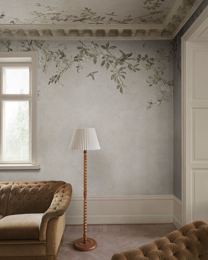 Transform your space with the Nico mural. This design evokes a serene Mediterranean pergola, featuring delicate blooming vines and small birds against a soft, lime-washed backdrop. 