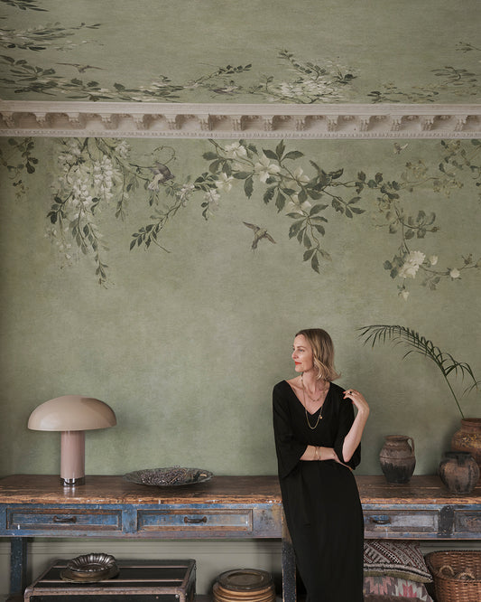 Embrace tranquil elegance with Nico's sage green backdrop, where delicate blooms and whimsical birds unite. This mural captures the enchanting charm of a classic Southern European pergola, creating a serene sanctuary with its exquisite floral details.
