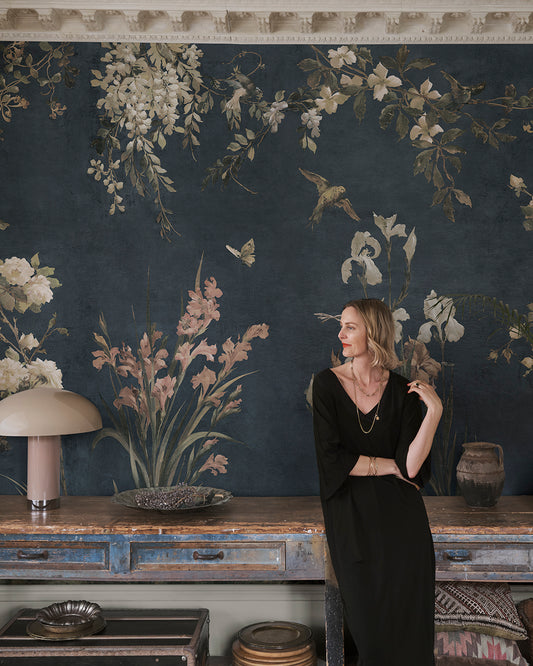 Immerse your space in the romantic elegance of Nicola's classic blue wallpaper. This mural, inspired by antique Southern European textiles, features birds and flowers that artistically flourish against a deep blue backdrop