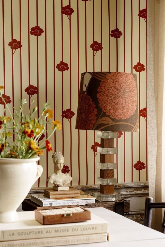 This wallpaper features soft, muted stripes that bring structure and calm, while the flowers defy the order, claiming space and growing freely.