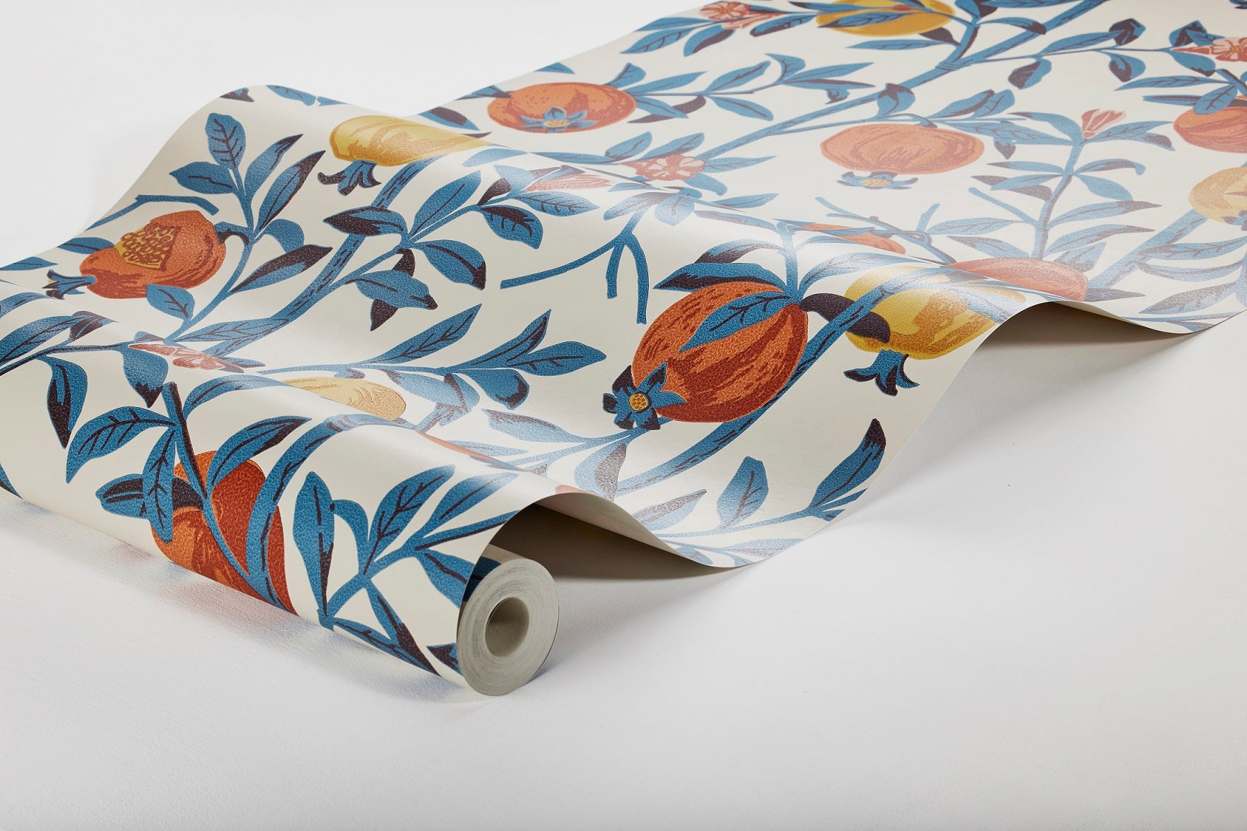 Colored in shades of vibrant blues, yellows and oranges on a white background, our Granatäpple wallpaper, uses an overprint technique allowing new shades to emerge in the mix of two prints. 