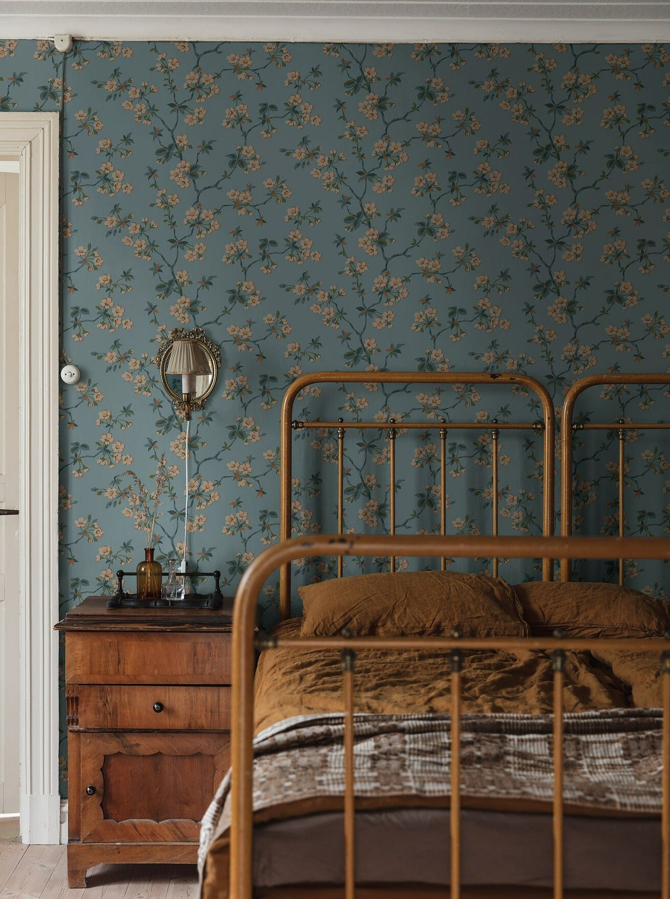 Set on a pastel blue background with green, white and pale orange detailing, our Trädgårdsstaden wallpaper offers a truly calm and classic style. 